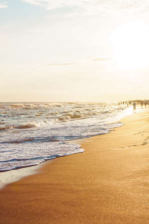 Waves on the seaside in the rays of the evening sunの写真素材