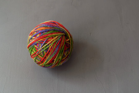 a ball of multi-colored woolen threads for knitting on a gray background close-up, copy spaceの写真素材