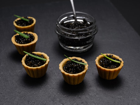 a delicacy of Russian cuisine - tartlets with natural black sturgeon caviar on a slate plateの写真素材