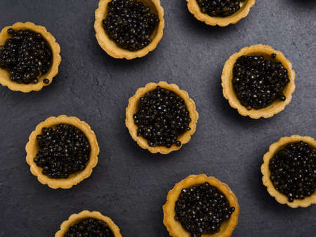 tartlets with natural beluga black caviar on a slate background close-upの写真素材