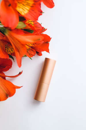 atomizer in a golden case and red alstroemeria on a white background - flatleyの写真素材