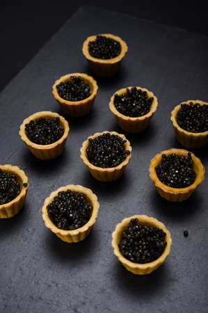 tartlets with natural beluga black caviar on a slate background close-upの写真素材