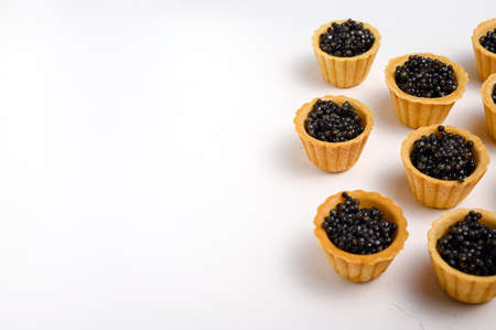 tartlets with natural black caviar on white background, copy spaceの写真素材