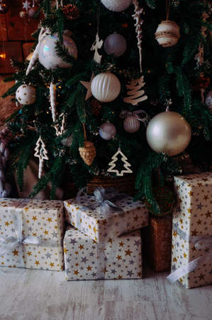 gifts in beige boxes with stars under the christmas treeの写真素材