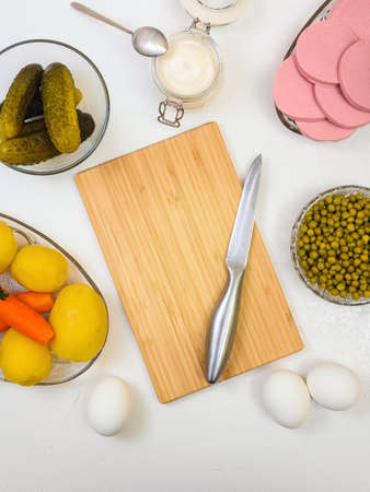 ingredients for making Russian salad Olivier and bamboo cutting board - cooking festive dishの写真素材