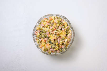 a traditional dish of Russian cuisine - Olivier in a vintage crystal salad bowl on a white plate - flatlayの写真素材