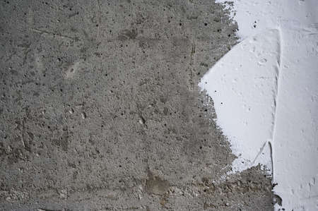 white plaster on a gray concrete wall close-upの写真素材