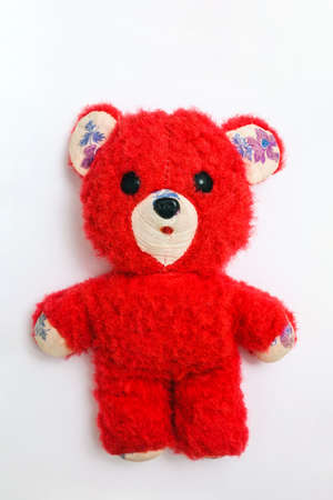 old soft toy - red teddy bear on a white backgroundの写真素材