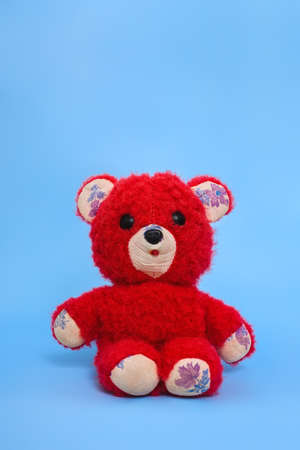 vintage children's toy - red teddy bear on a blue backgroundの写真素材