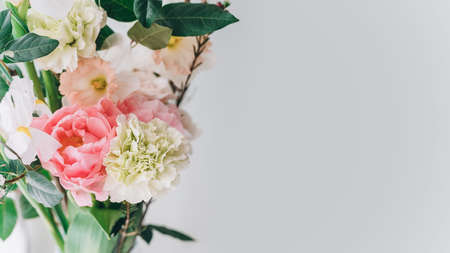 beautiful bouquet of carnations, daffodils, spray roses and white irises on a gray background, copy spaceの写真素材