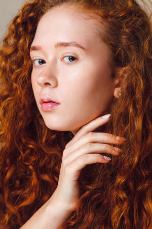 close-up portrait of a red-haired curly girl. young skin and hair care conceptの写真素材