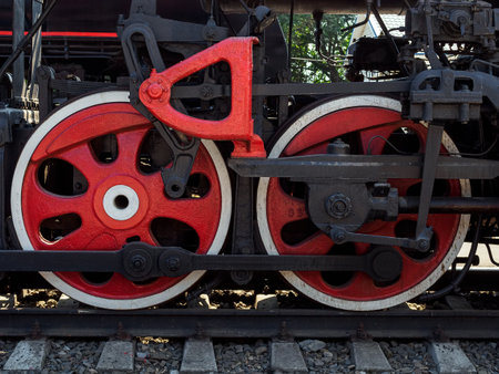 two huge red metal wheels of an old steam locomotiveの写真素材