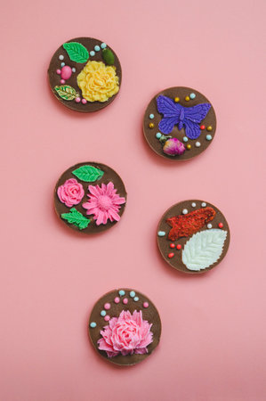 handmade chocolates decorated with edible flowers, dried strawberries, dragees and butterflies on...
