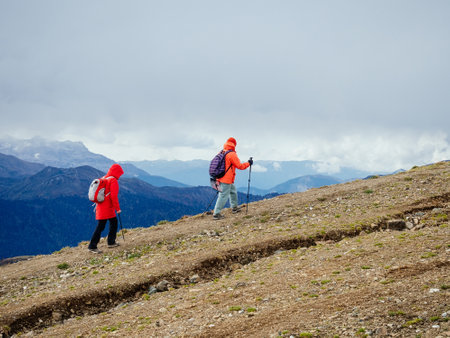 Two women are hiking high in the mountains in autumnの写真素材