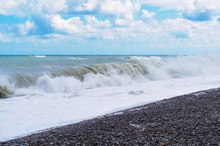 a sea storm on a rocky shore in cloudy weatherの写真素材