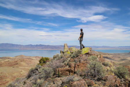 Virginia Mountains, Nevada - May 2020: A solo male hiker stands atop a peak in the Virginia Range...