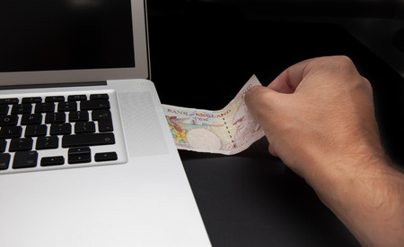 Cyber theft concept shot with laptop and moneyの写真素材