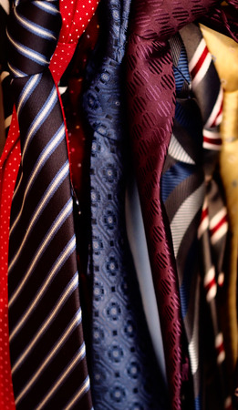 Juble of ties hanging in a wardrobeの写真素材