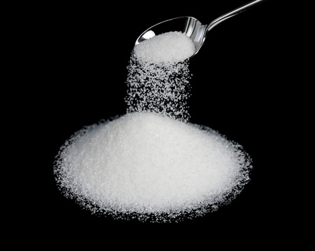 A spoonful of sugar on a black background