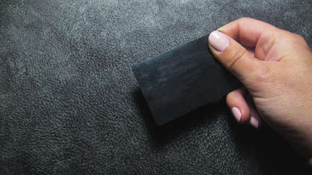 Dark gray background. Girl holding a business cardの写真素材