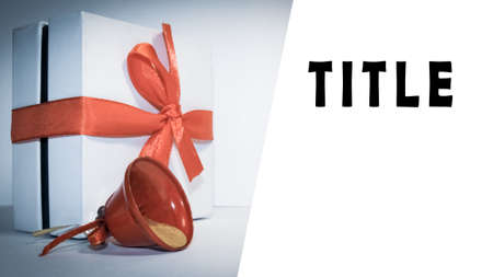 New Year's gift with a red ribbon. In the photo there is a gift box and a red bell.