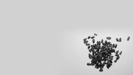 Black sunflower seeds close-up on the table. Handful on gray backgroundの写真素材