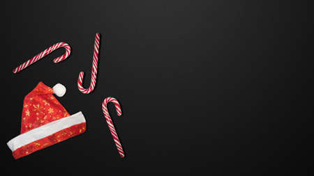 Red Christmas hat and candies on a black background.の写真素材