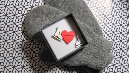 An open gift. Gloves. open the gift with gloves. The box contains a heart and toy skates.の写真素材