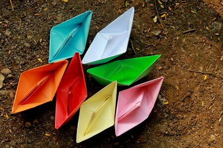 Colorful paper boats on barren landの写真素材