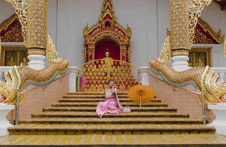 Asian Girl in Thai costume posing at old religious Buddhist temple in Chiang Maiの写真素材