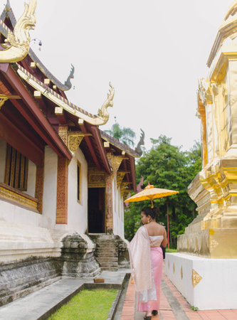 Woman in Thai costume facing back near Old Buddhist temples of Northern Thailandの写真素材