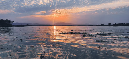 Exotic sunset with sunlight shining on waters of Kaptai lakeの写真素材