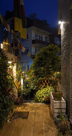Cozy Garden Pathway at Night with Prayer Flags and Warm Lighting in Nepalの写真素材