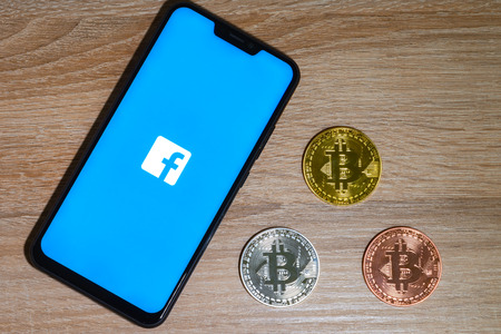 Bitcoin coin with the Facebook logo screen backgroundのeditorial素材