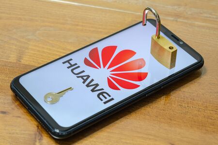Huawei logo in background with a unlock padlock and a key on smartphone