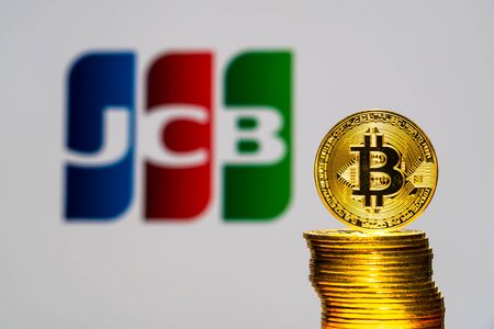 Gold Bitcoin coins with the JCB logo on background screen. A new type of business finance conceptのeditorial素材