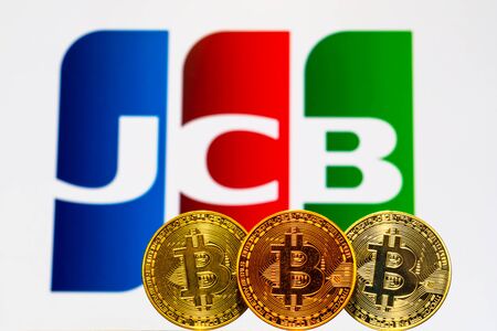 Gold Bitcoin coins with the JCB logo on background screen. A new type of business finance conceptのeditorial素材