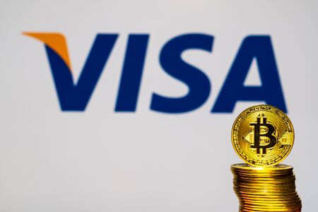 Gold Bitcoin coins with the Visa Plus System logo on background screen. A new type of business finance conceptのeditorial素材