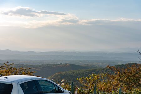 Car on the top of the mountain. A beautiful scenic view during autumn foliage season.の写真素材