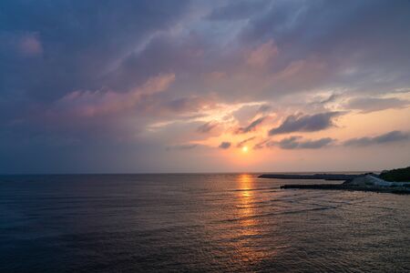 Colorful orange blue sky during sun set, gold sky sun clouds in eveningの写真素材