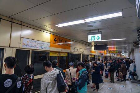 Taipei metro station hall and platform. Subway passengers walk through the enormous underground...