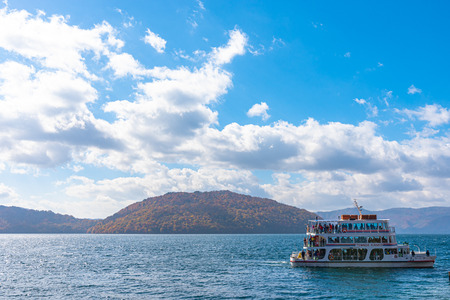 Beautiful view, clear blue sky, white cloud, cruise ship in sunny day with autumn foliage background.のeditorial素材