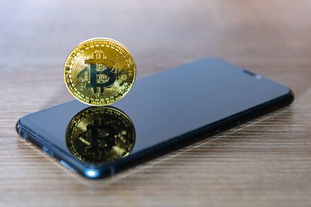 Bitcoin coin with a smartphone screen.の写真素材