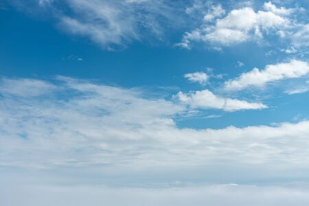 Clouds and blue sky background, viewed from an airplane window.の写真素材
