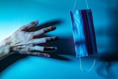 A hand want to taking a medical mask. Medical concept against virus and bacteriaの写真素材