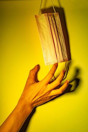 A hand want to taking a medical mask. Medical concept against virus and bacteriaの写真素材
