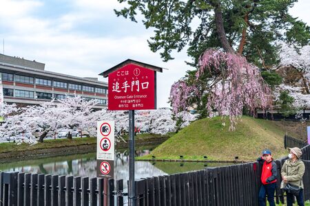 Hirosaki Park in springtime cherry blossom season sunny day at East Gate Entrance. Visitors Enjoy the Beauty Full Bloom Sakura Trees Flowers. Aomori Reflection, Japanのeditorial素材