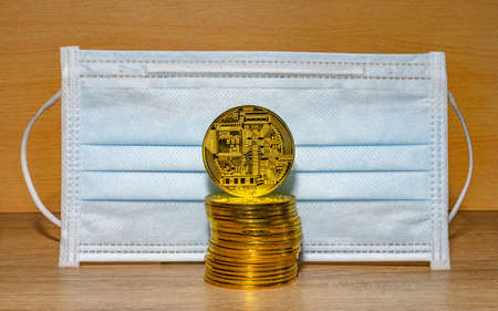 Gold coins with a medical mask. A business finance conceptのeditorial素材