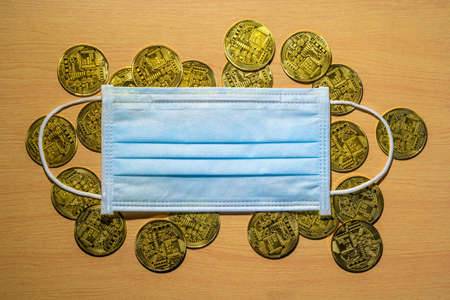 Gold coins with a medical mask. A business finance conceptのeditorial素材