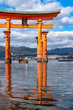 Close-up Floating orange red giant Grand O-Torii gate stands in Miyajima island bay beach at low tide on sunny day. Hiroshima City. The Three Views of Japan. Translation on gate: Itsukushima Shrineのeditorial素材